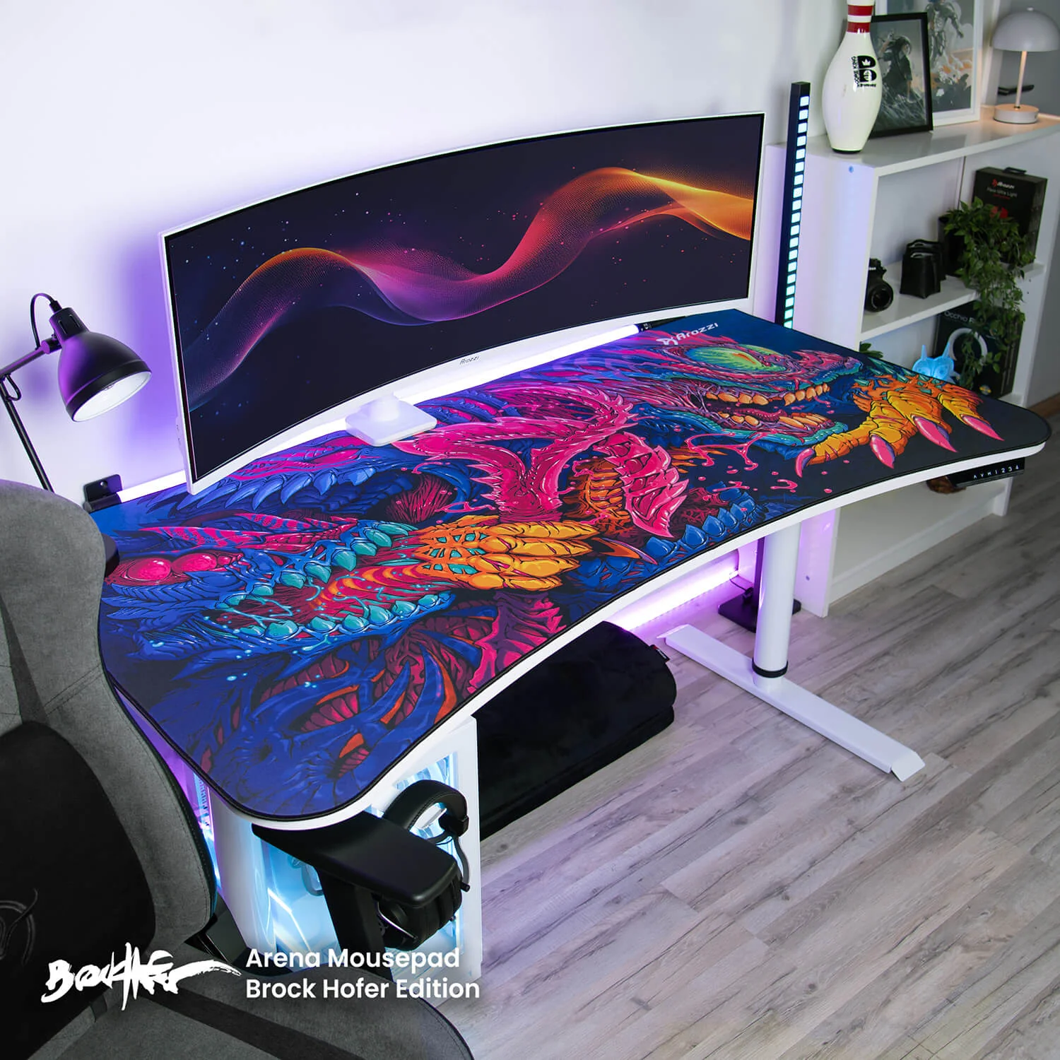 Gaming desk with a curved monitor and a vibrant dragon-themed mousepad.