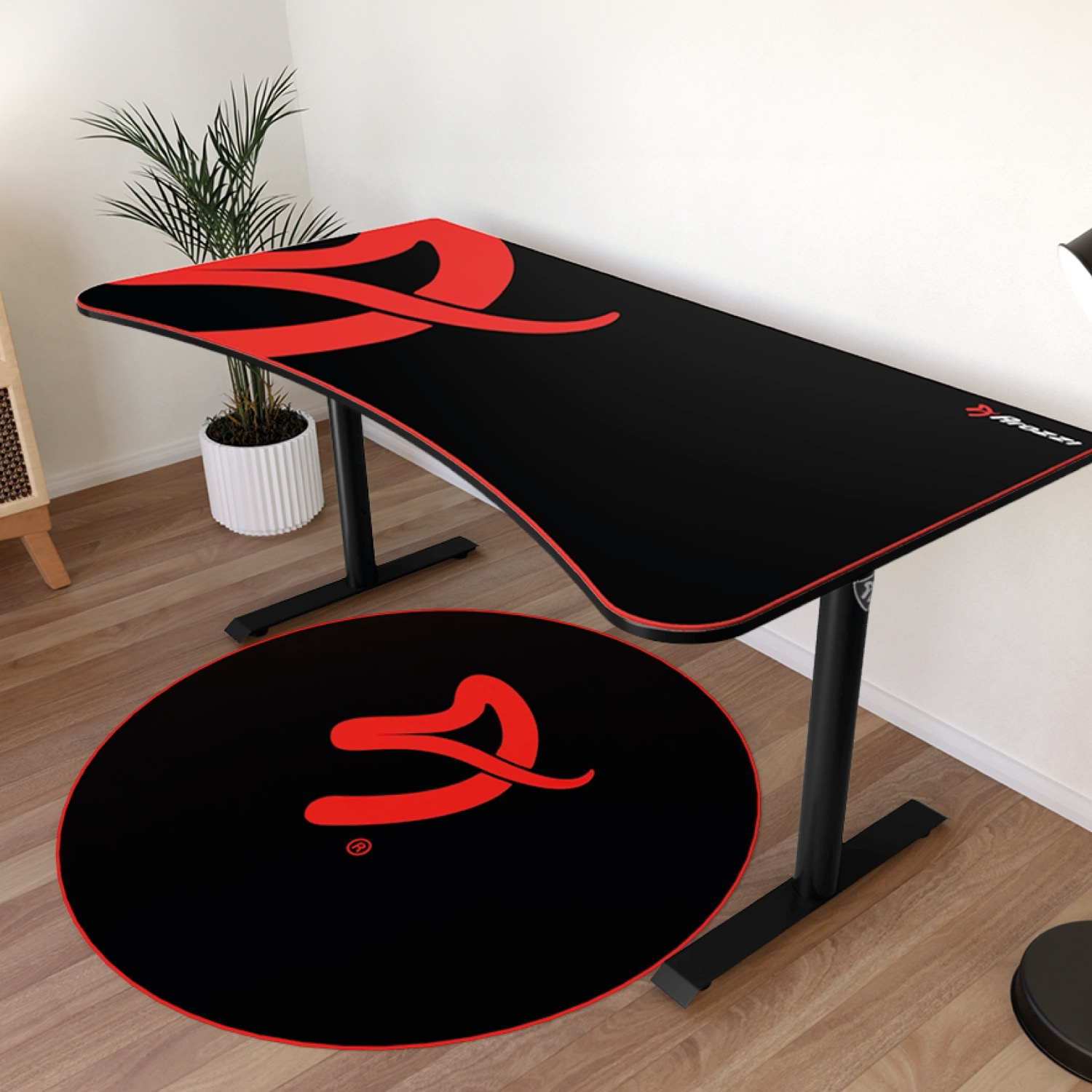 Schwarzer Schreibtisch mit roten Akzenten und passender runder Matte.