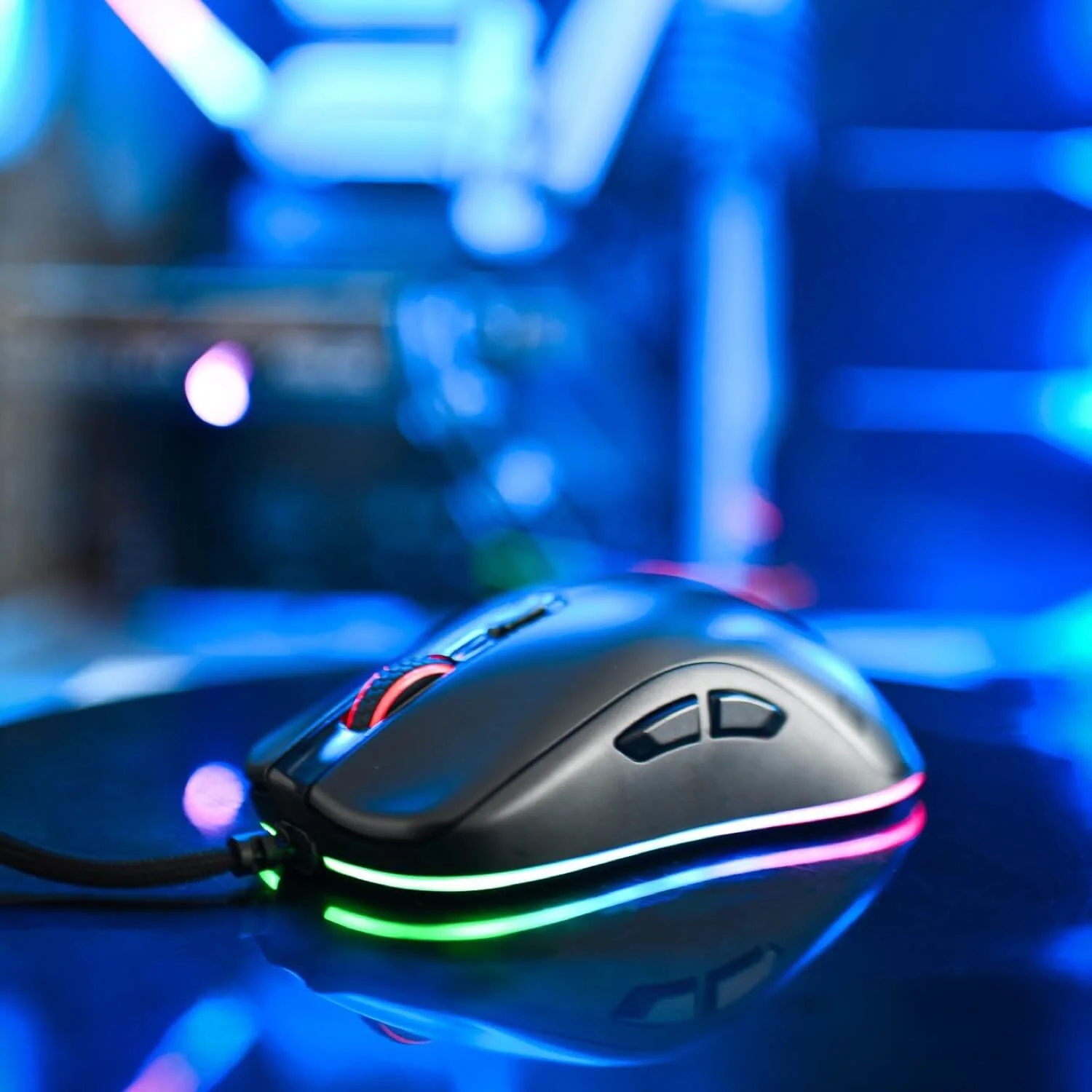 Een zwarte gamingmuis met RGB-verlichting op een reflecterend oppervlak.