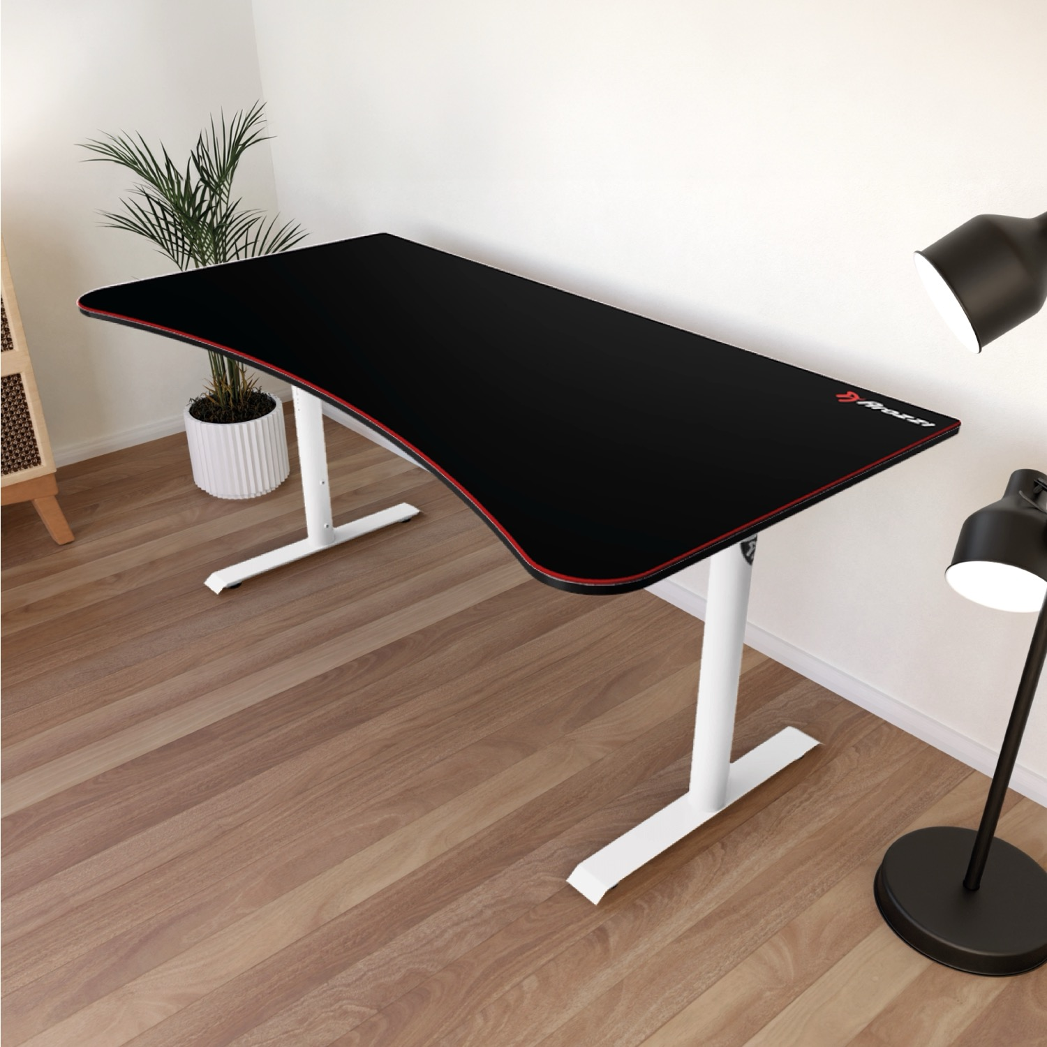 Een zwart bureau met rode rand op witte poten staat op een houten vloer.