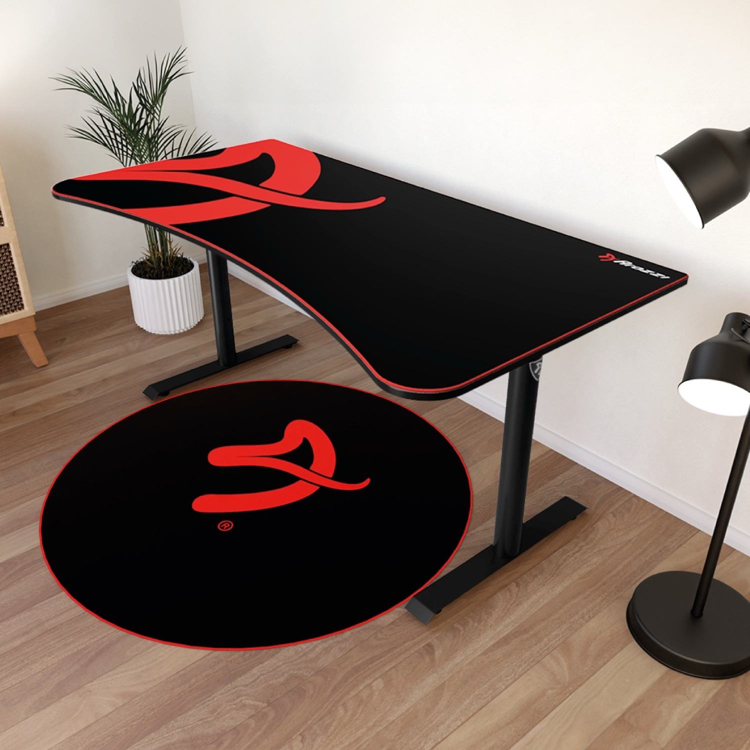 Una scrivania nera con design rosso, un tappeto rotondo e due lampade.