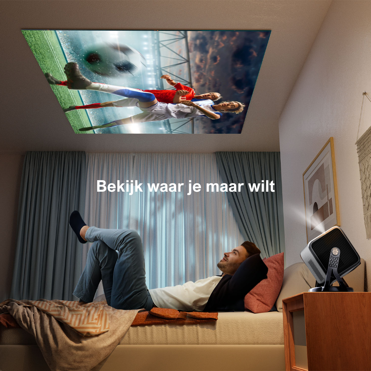Homme allongé sur lit regarde football projeté au plafond, projecteur sur table.