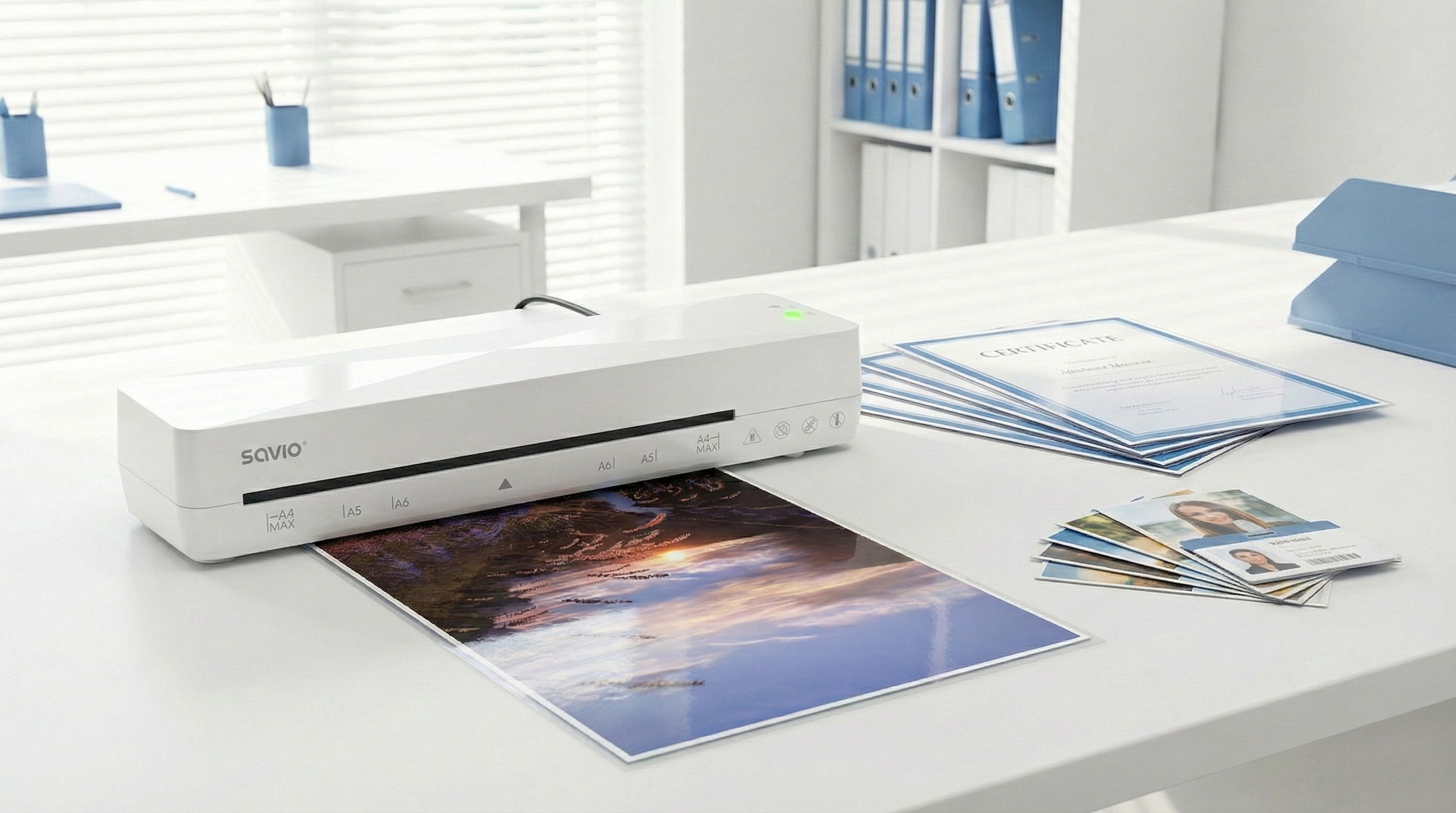 Biała laminarka Savio przetwarza zdjęcie zachodzącego słońca.