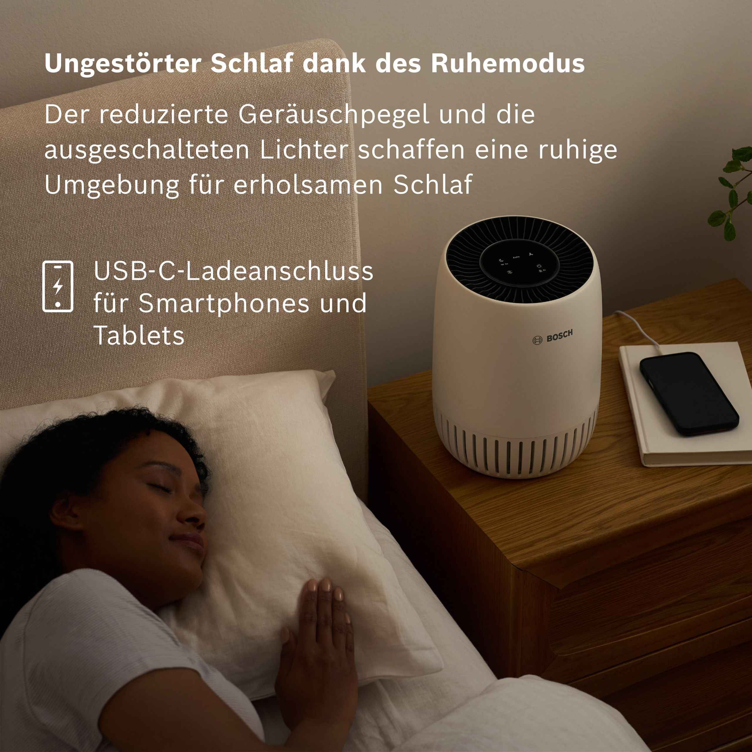 Donna dorme a letto accanto a un purificatore d'aria Bosch con porta USB-C.