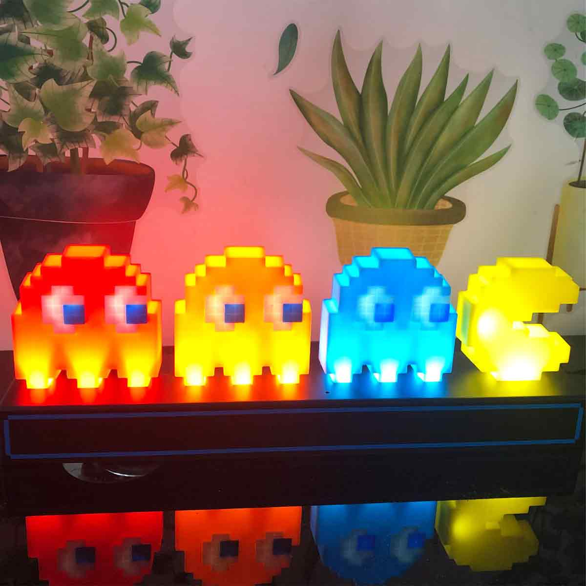 Vier Pac-Man-Geisterlampen in Rot, Orange, Blau und Gelb stehen nebeneinander.