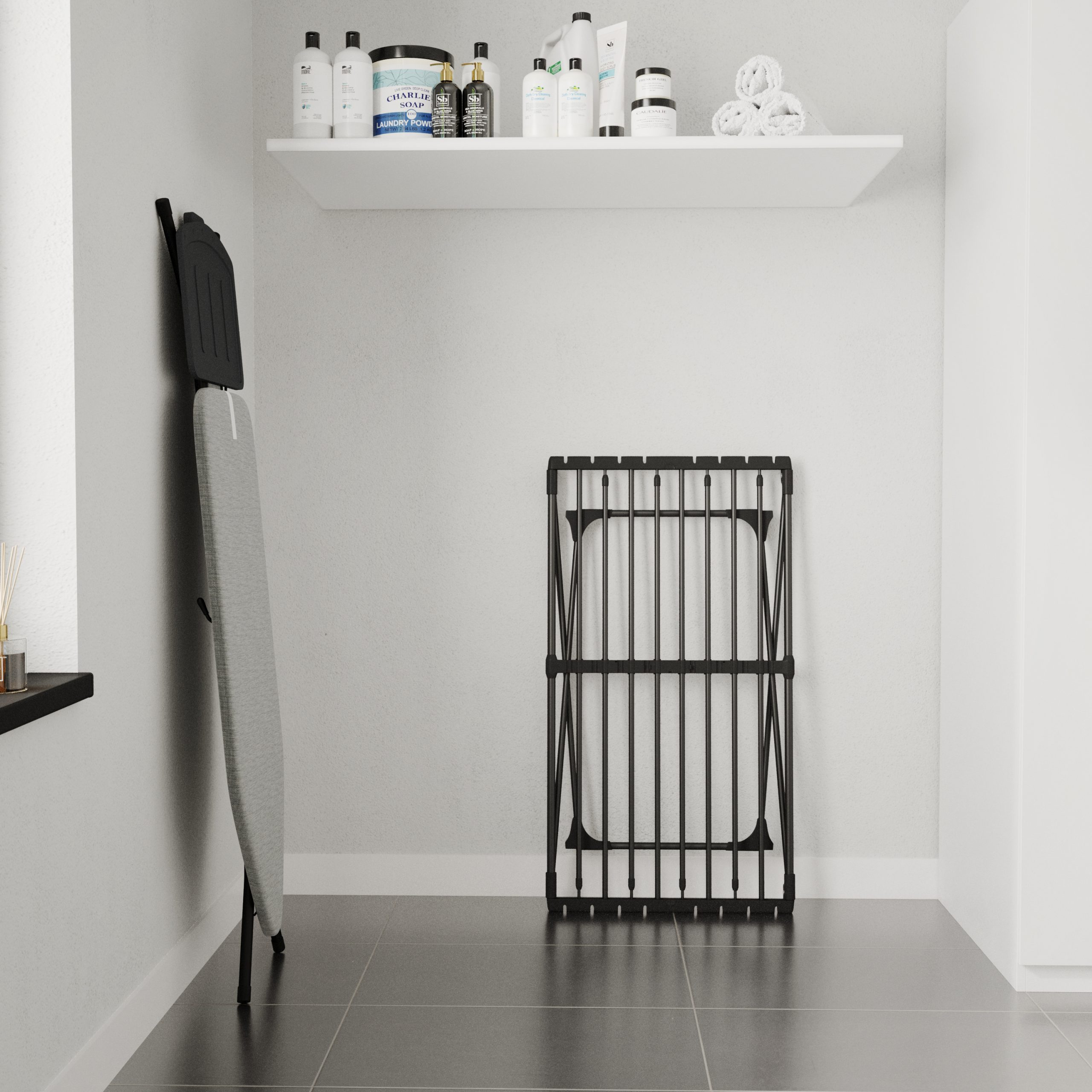 Une planche à repasser est contre le mur, à côté un étendoir à linge plié.