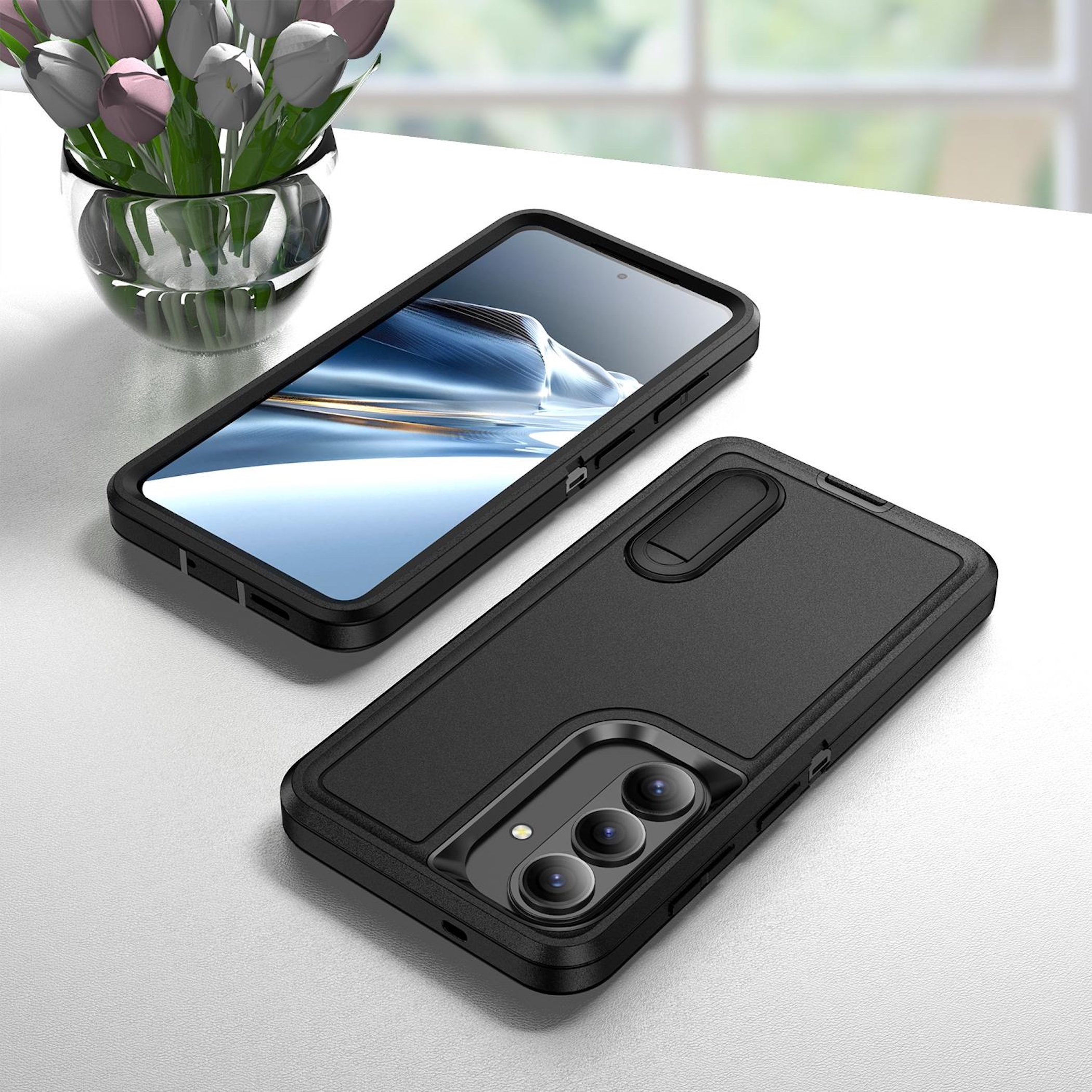 Un teléfono inteligente negro yace junto a un jarrón de cristal con tulipanes coloridos.