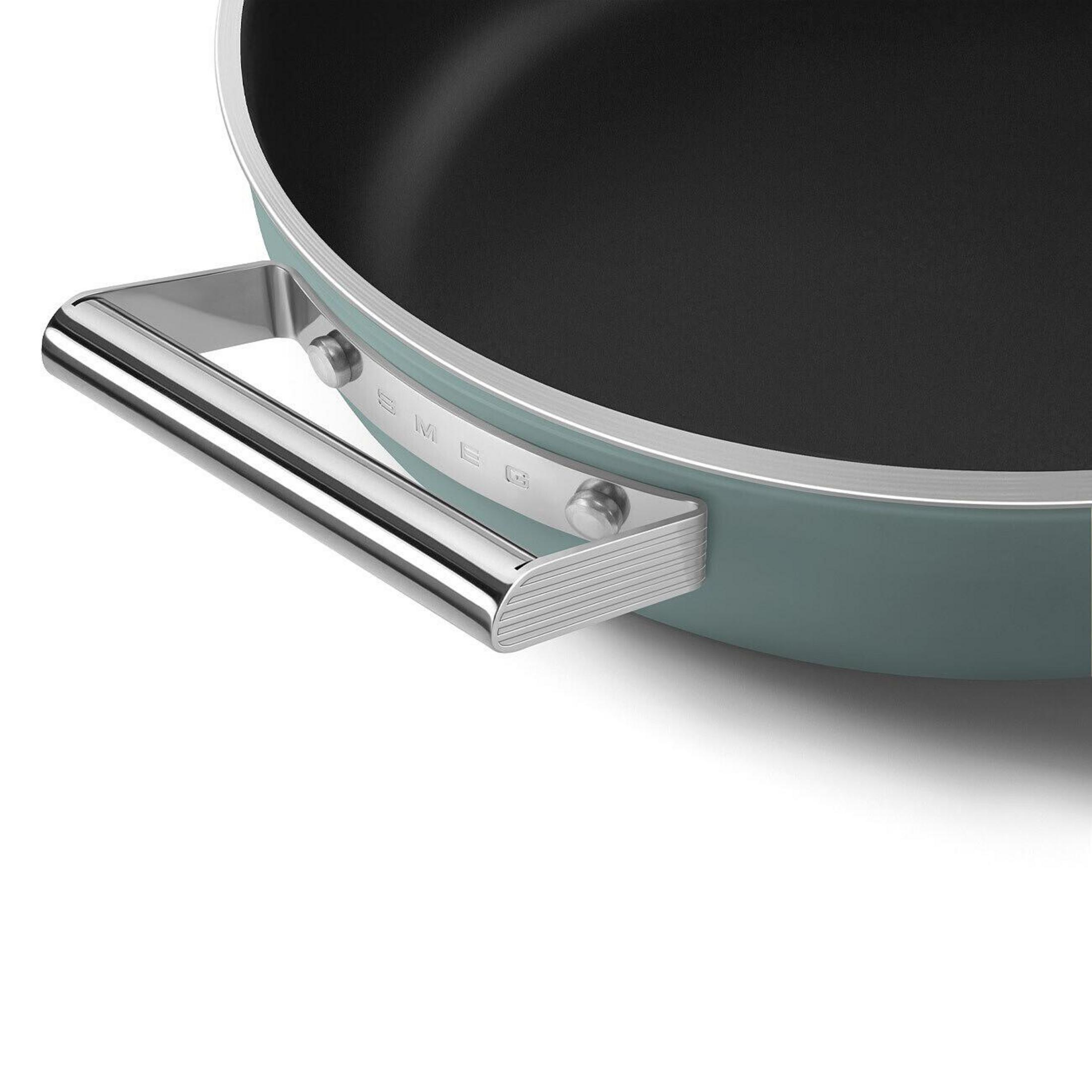 Primer plano de una sartén turquesa con asa plateada y logo Smeg.