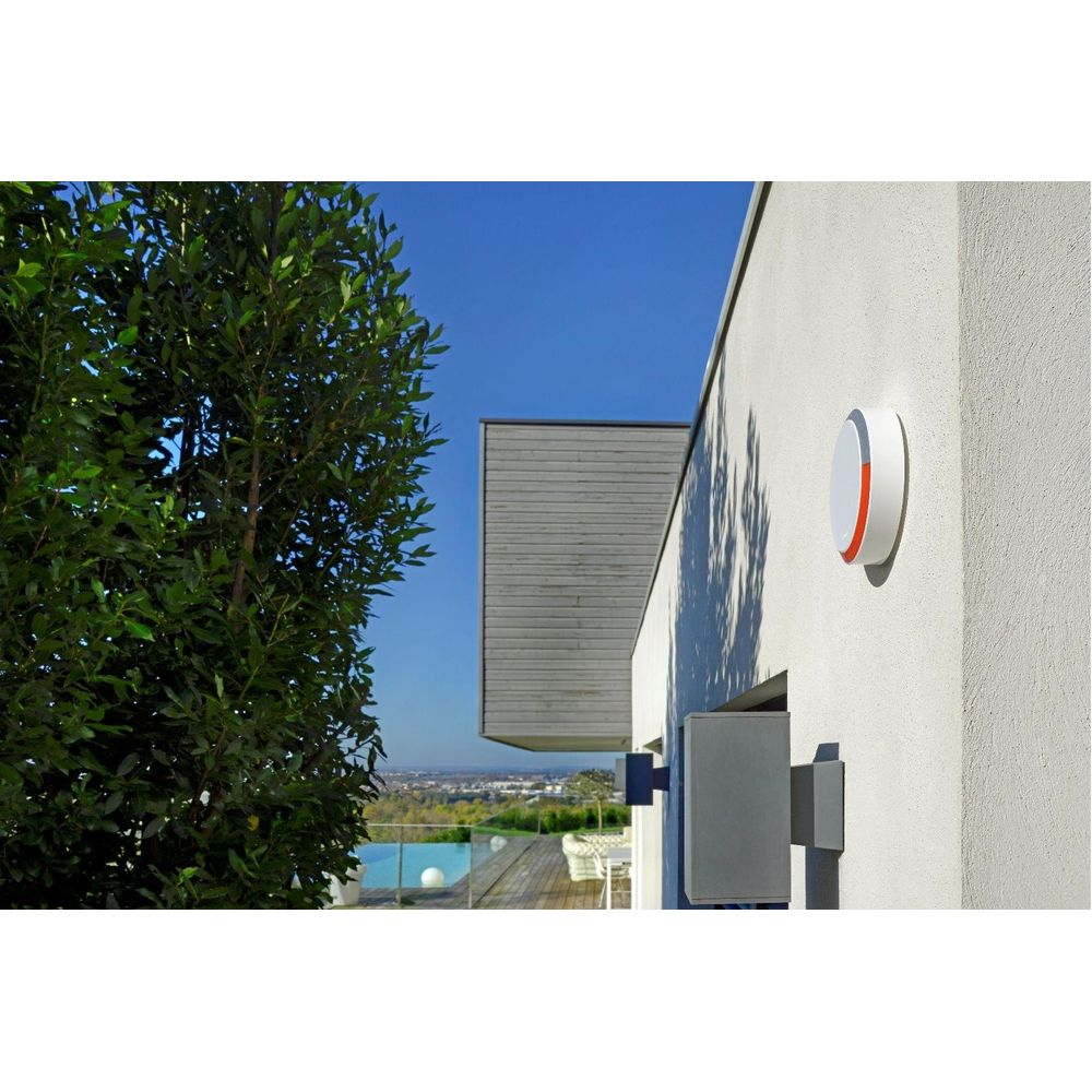 Ein modernes Haus mit einem Pool und einer Aussicht. Ein Baum im Vordergrund.