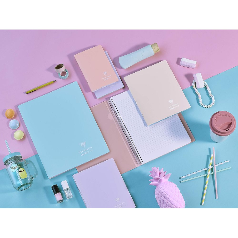 Pastellfarbene Notizbücher, Stifte, Nagellack, Glas und Ananas-Deko.
