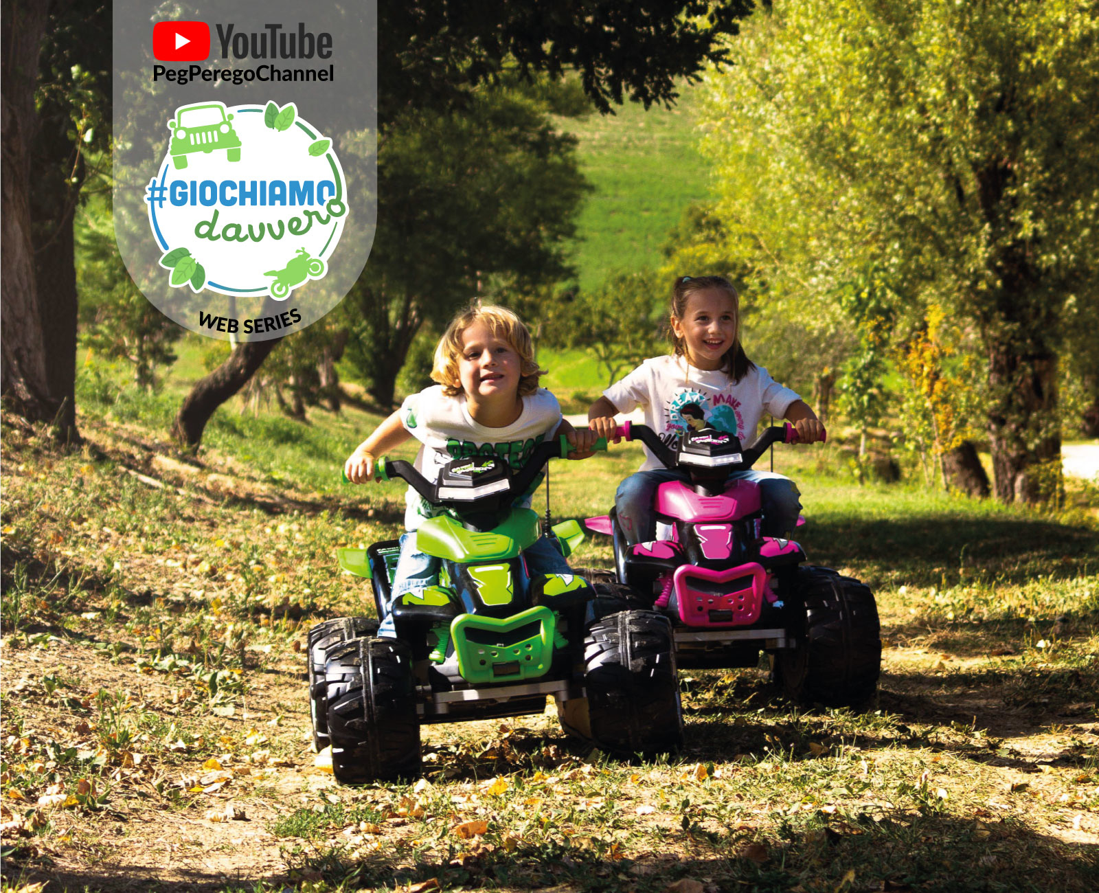 Zwei Kinder fahren auf grünen und pinken Quads im Freien auf einem Feld mit Bäumen.