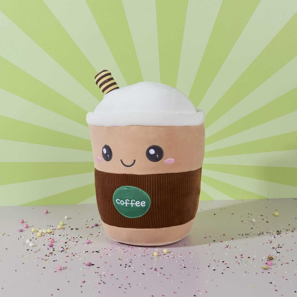 Una simpatica tazza di caffè di peluche con una faccia sorridente siede su un tavolo con zuccherini colorati.