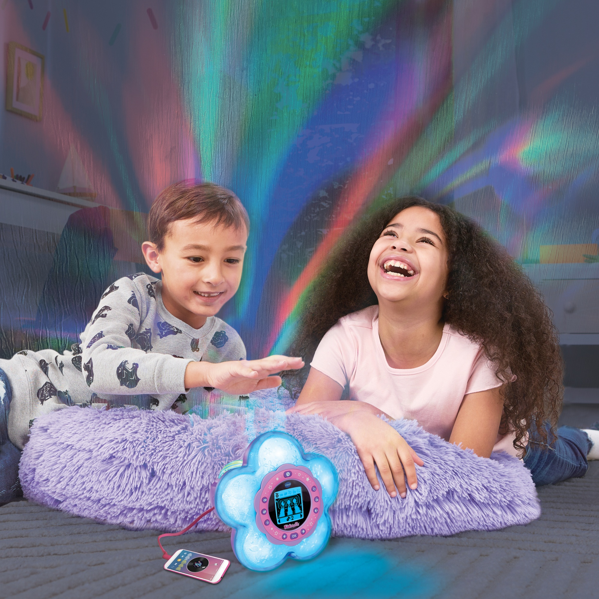 Zwei Kinder liegen auf dem Boden vor einem Projektor, der Lichtmuster an die Wand wirft.