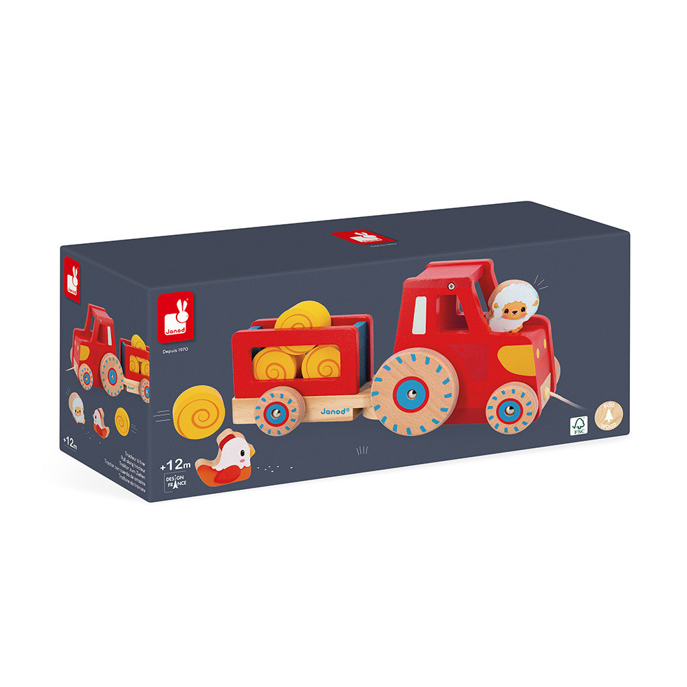 Roter Holzspielzeug-Traktor mit Anhänger, beladen mit Garnrollen. Ein Schäfchen sitzt im Traktor.