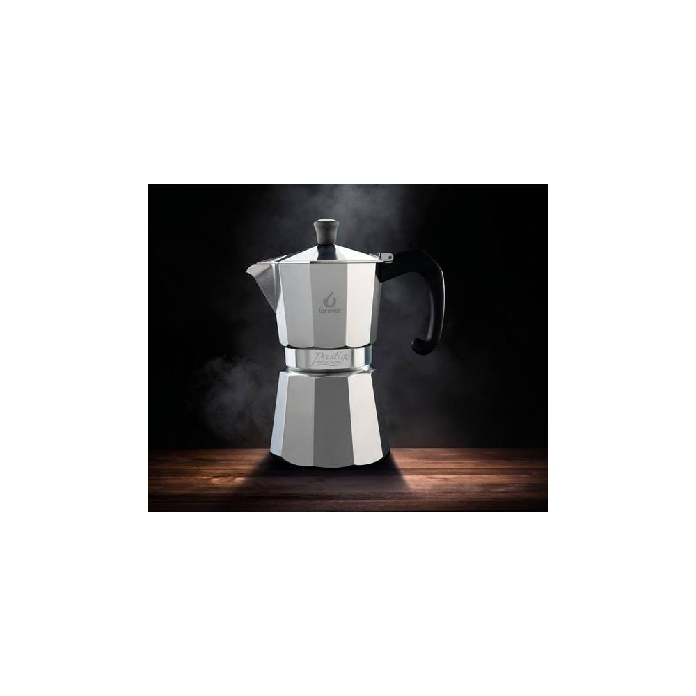 Una caffettiera espresso argentata con manico nero su tavolo di legno.