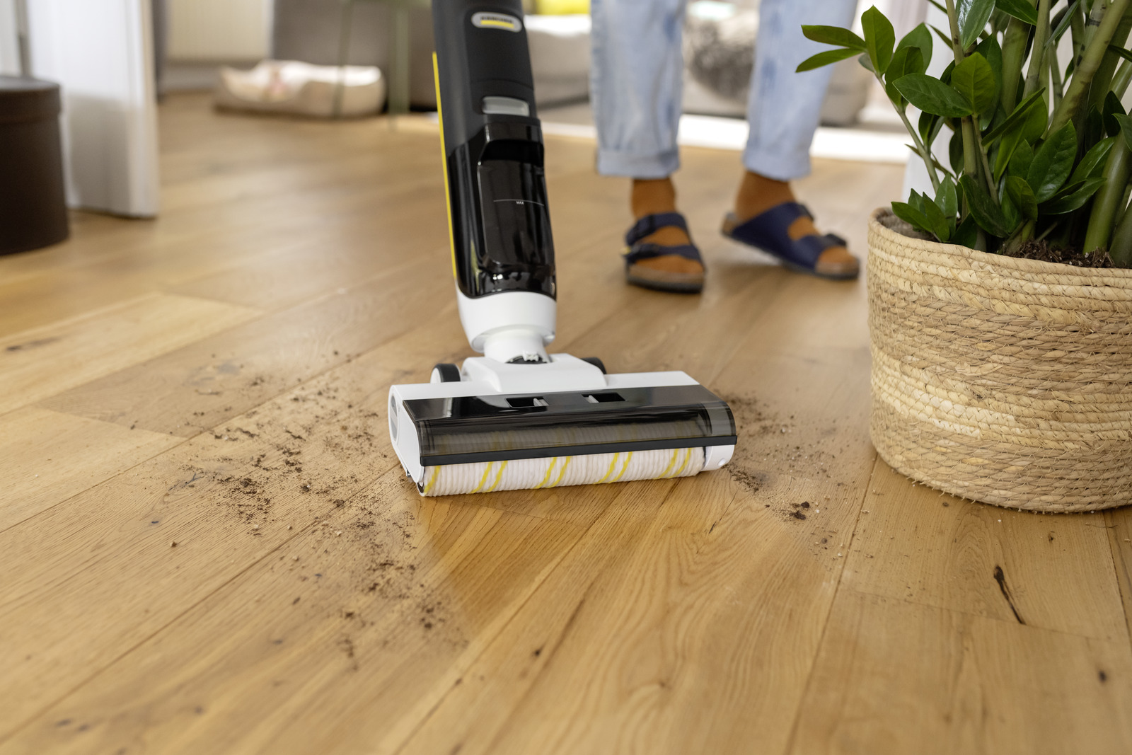 Un pulitore per pavimenti senza fili pulisce lo sporco da un pavimento in legno.