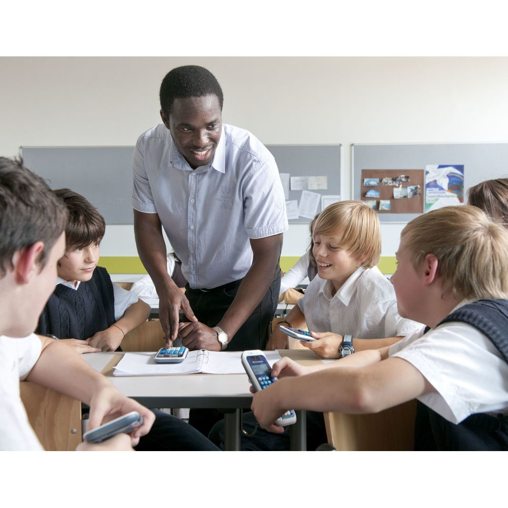 Lehrer zeigt Schülern einen Taschenrechner in einem Klassenzimmer.