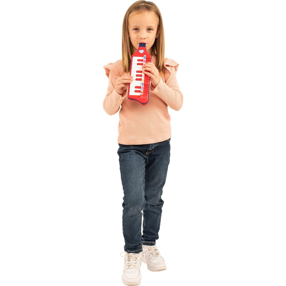 Ein Mädchen mit einem Melodica, das auf einem weißen Hintergrund steht.