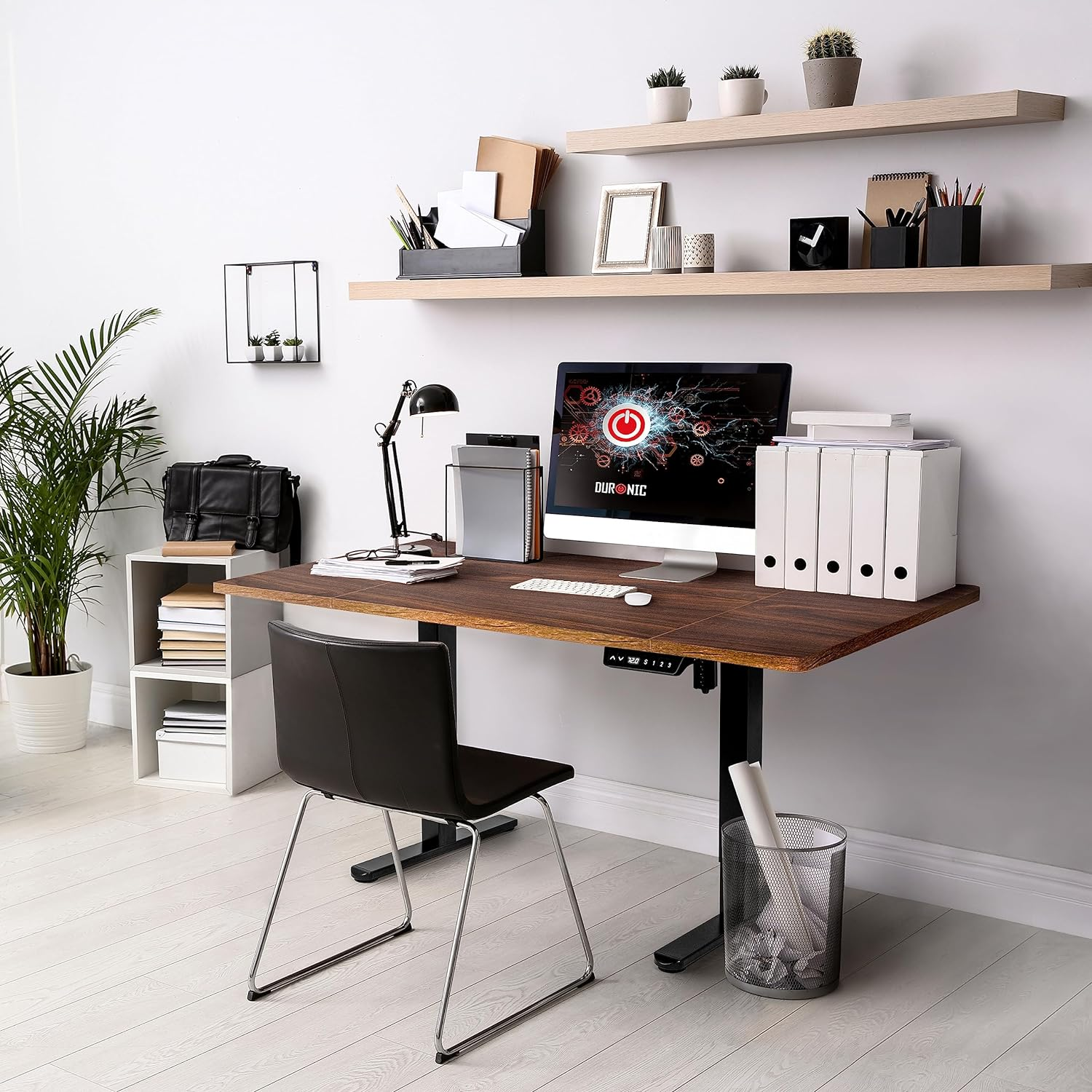 Ein moderner Büroschreibtisch mit Computer, Stuhl, Pflanze und Regalen.