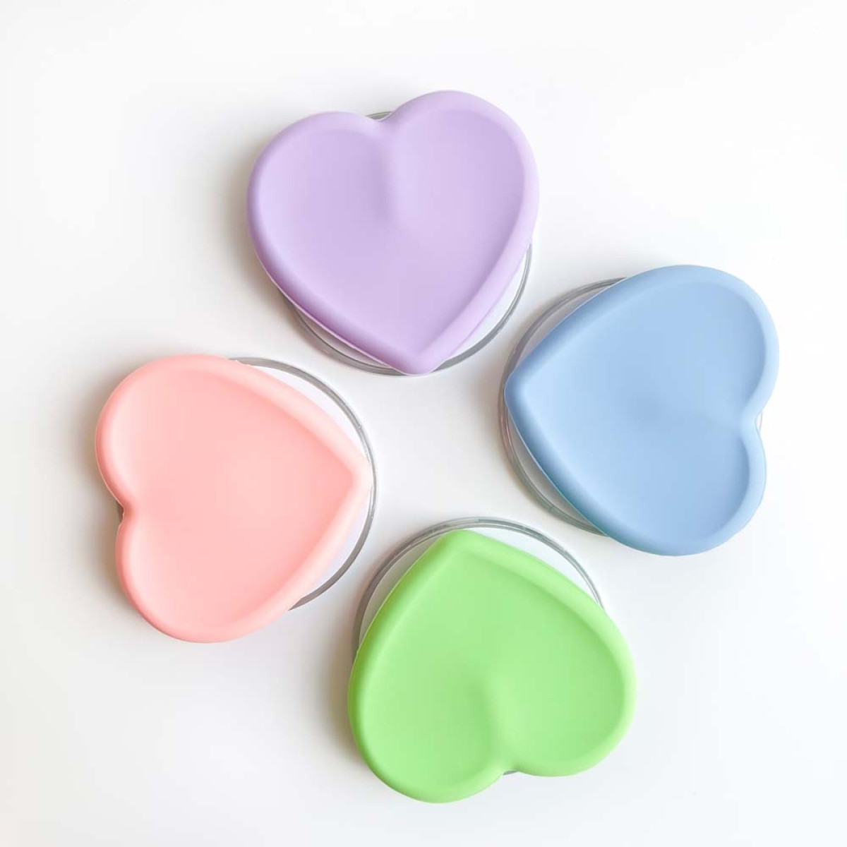 Vier herzförmige Behälter in Pastellfarben, angeordnet in einem Kreis.