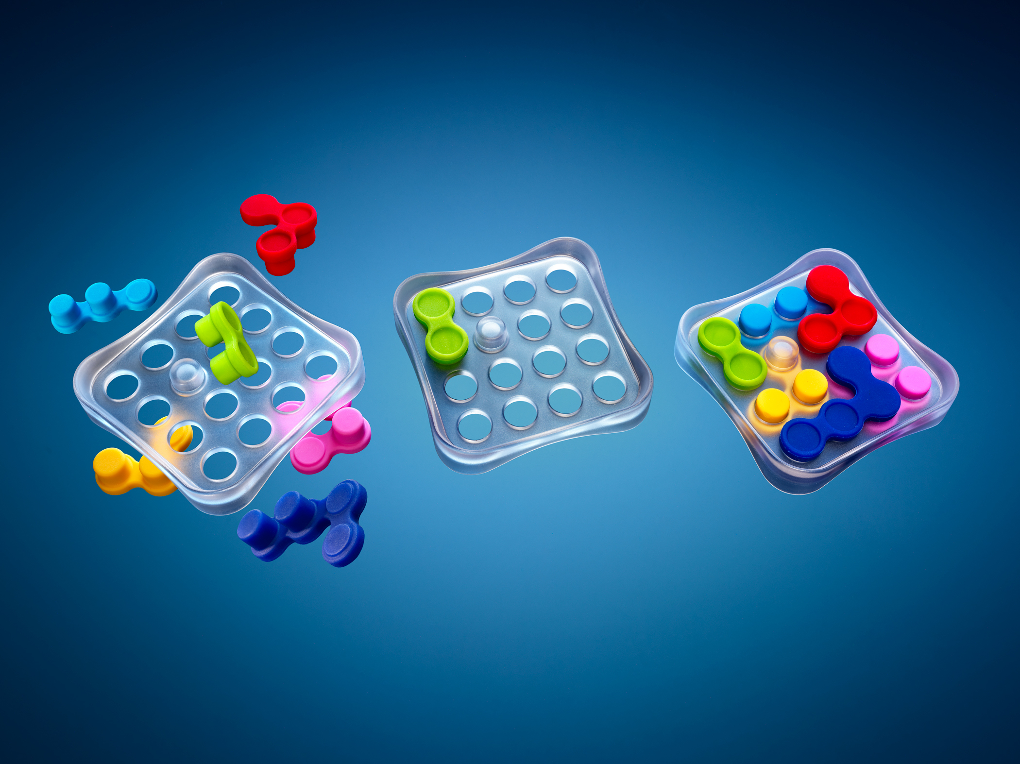 Drei transparente Puzzlebretter mit bunten Teilen auf blauem Hintergrund.