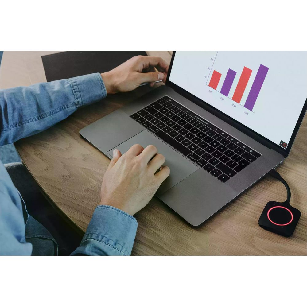 Uomo digita su laptop che mostra grafico a barre. Dongle nero con anello rosso.