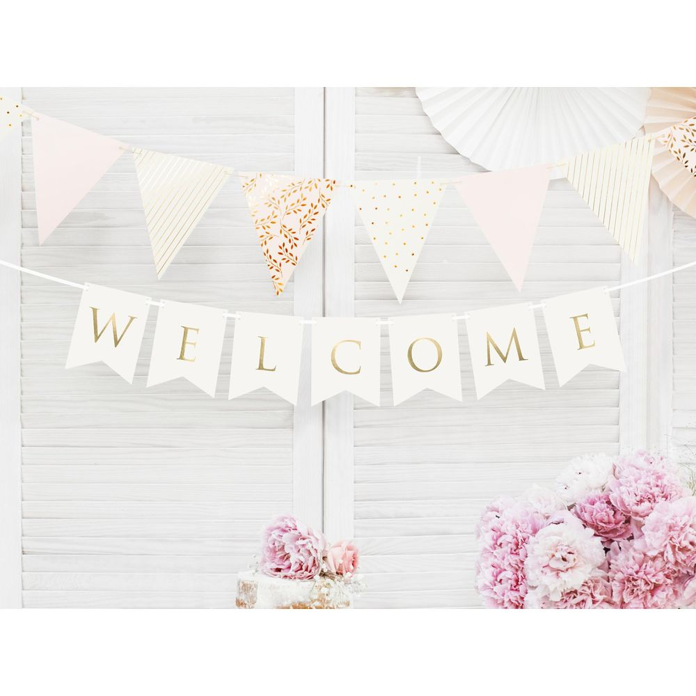 Willkommensbanner über Kuchen und Blumen vor weißem Hintergrund.