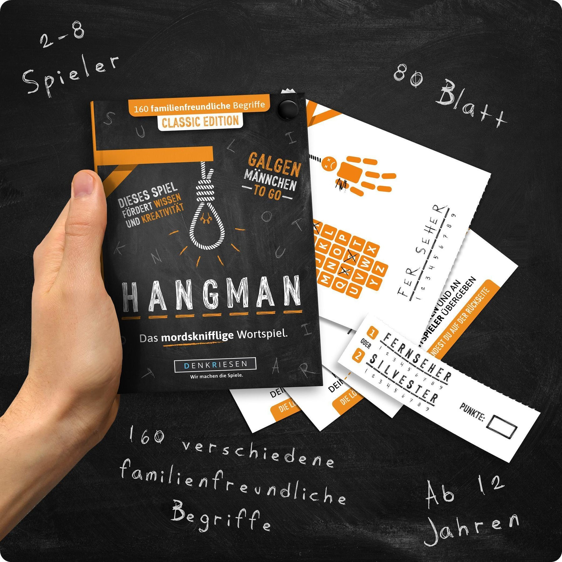 Ein Mann hält ein Hangman-Spiel. Spielkarten und eine Schnur sind zu sehen.