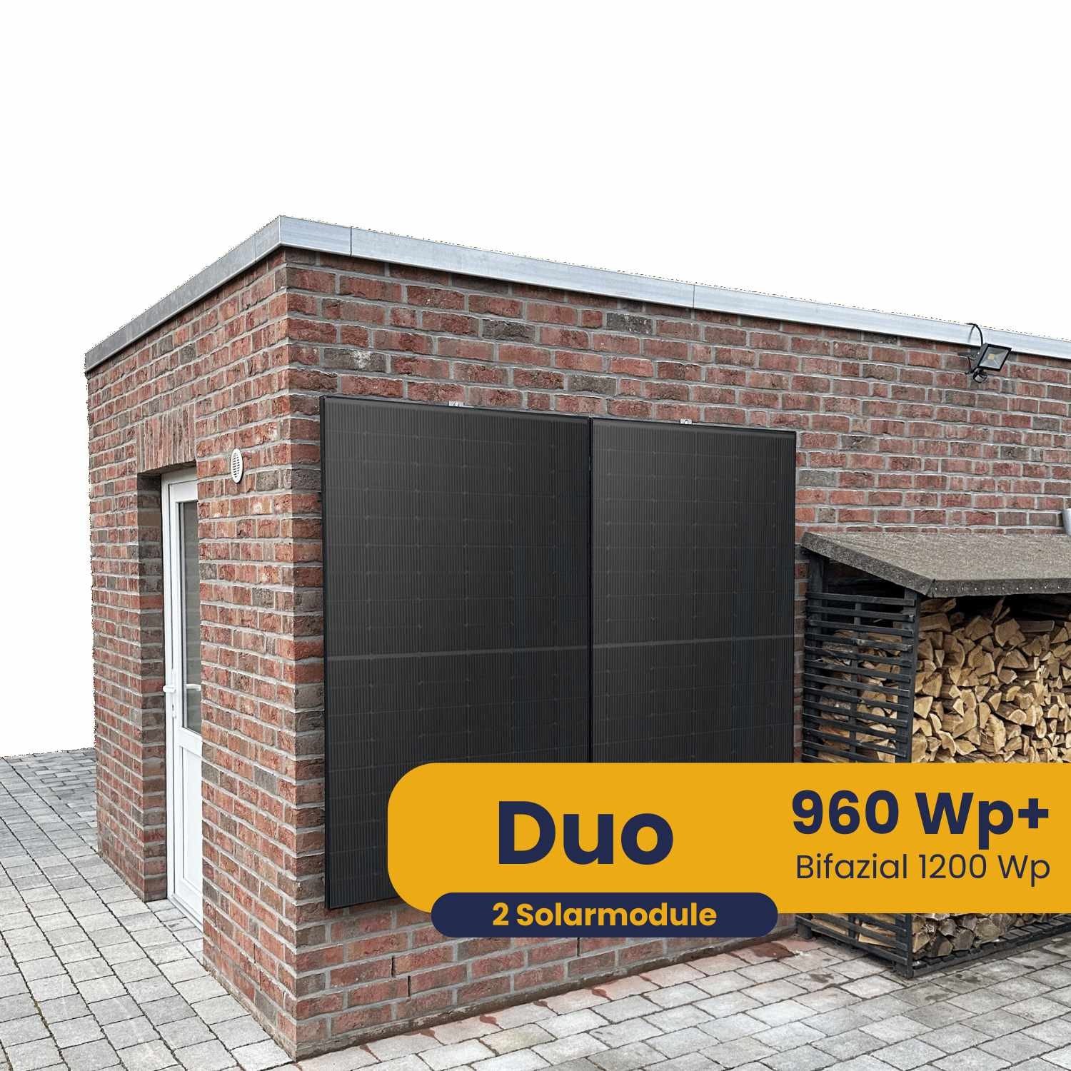 Zwei schwarze Solarmodule an einer Ziegelwand neben einem Holzstapel.