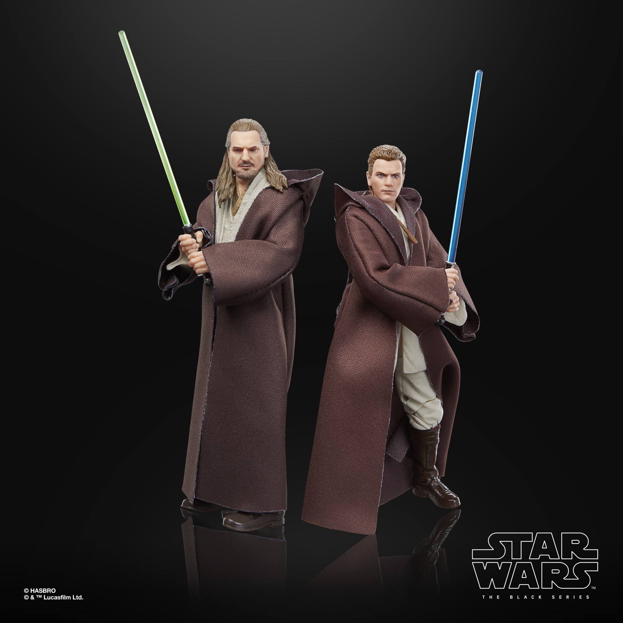 İki Star Wars figürü kahverengi cüppeli, biri yeşil, diğeri mavi ışın kılıcı tutuyor.