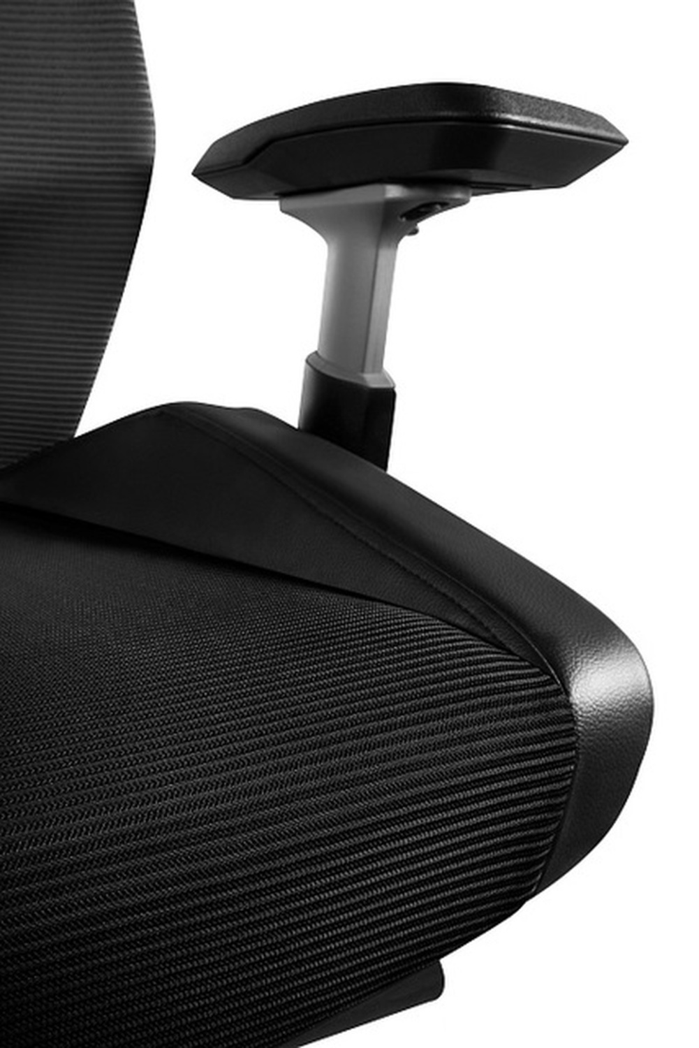 Zbliżenie czarnego fotela biurowego, pokazujące siatkowy tył i podłokietnik.