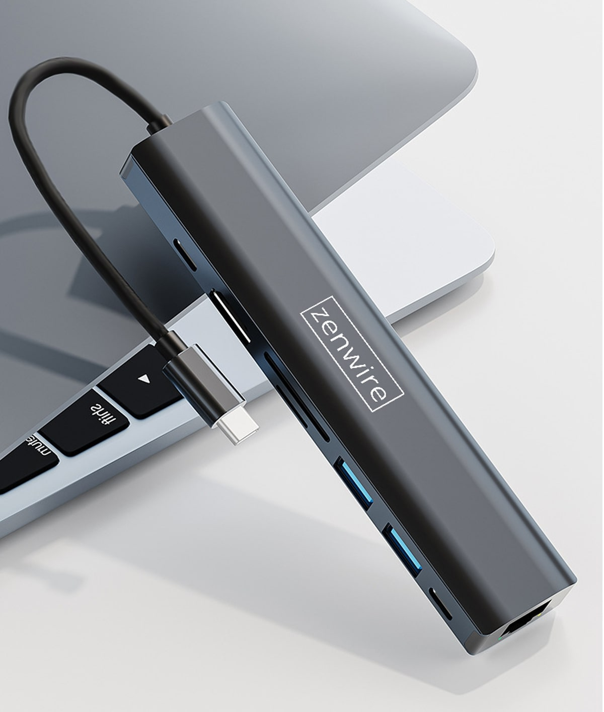 Szary hub USB-C z logo Zenwire leży na klawiaturze.