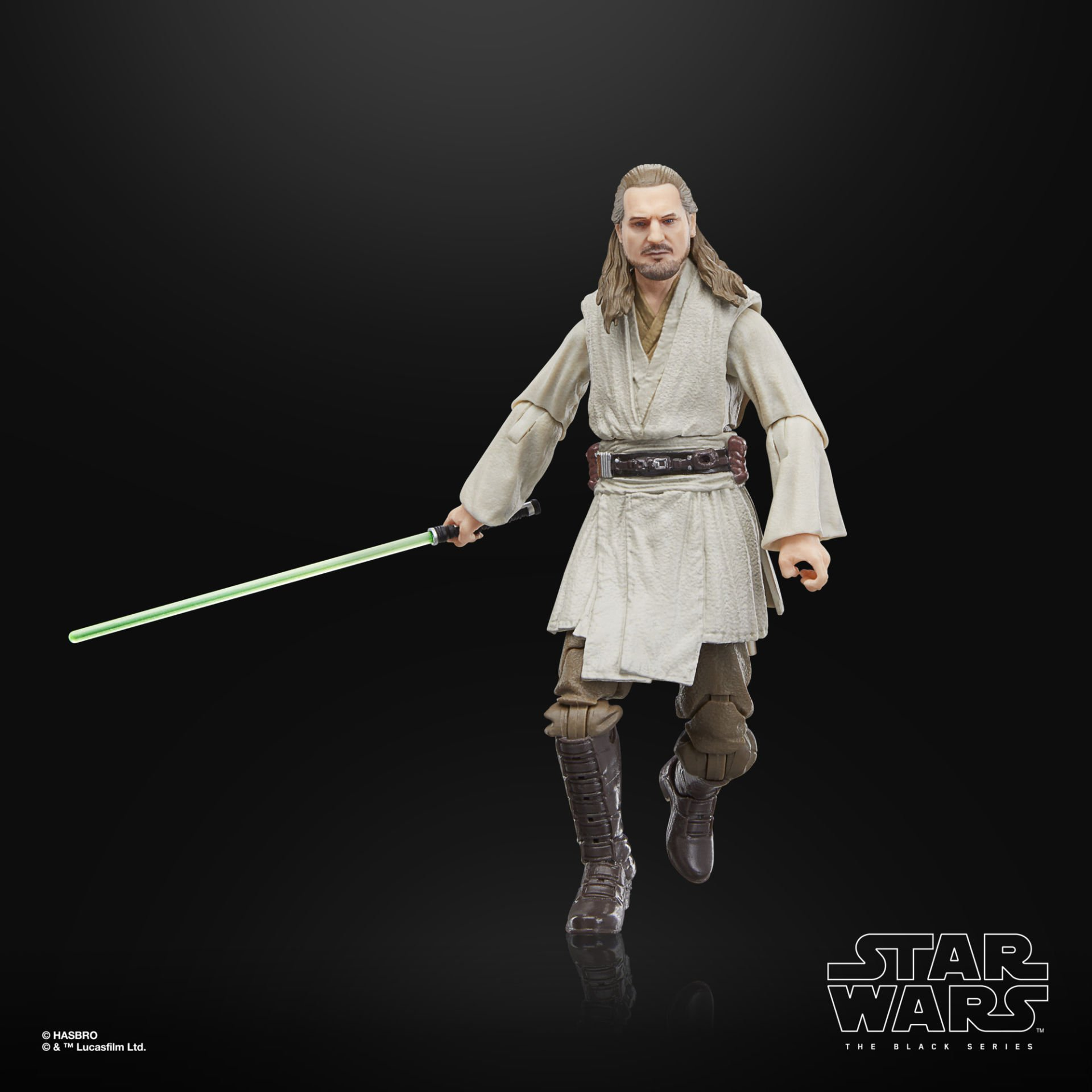 Siyah arka plan önünde yeşil ışın kılıcı tutan Qui-Gon Jinn aksiyon figürü.