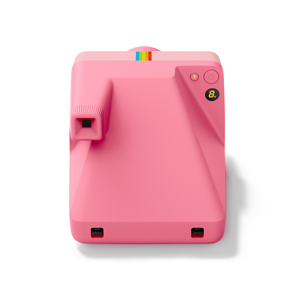 Eine pinke Sofortbildkamera mit Regenbogenstreifen und einem Zifferblatt.