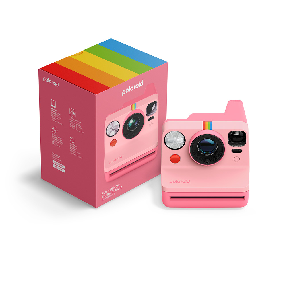 Eine rosa Polaroid-Sofortbildkamera mit einer Regenbogenstreifenverzierung neben ihrer Verpackung.