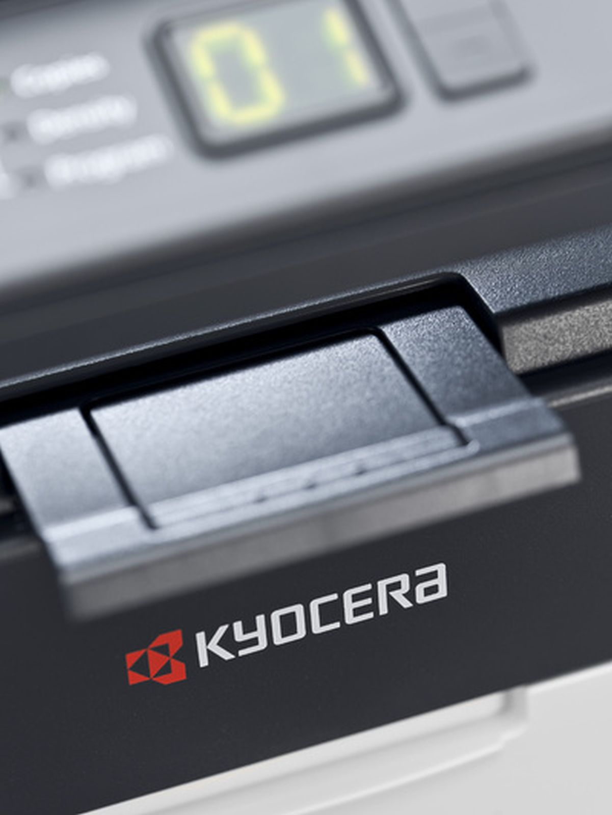 Zbliżenie drukarki Kyocera, pokazujące otwartą szufladę i cyfrowy wyświetlacz.