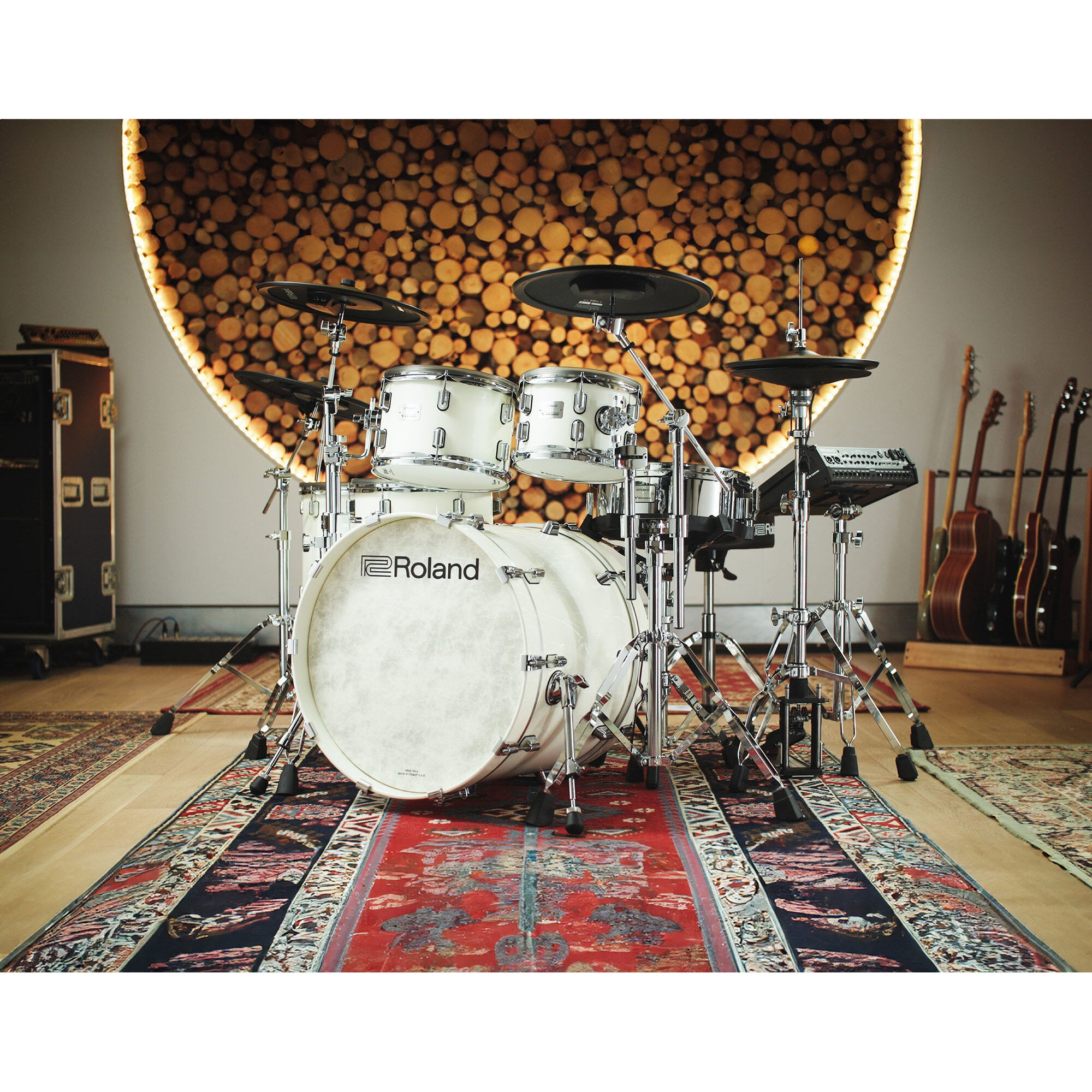 Een witte Roland elektronische drumstel staat op een kleed voor een muur van houtschijven.