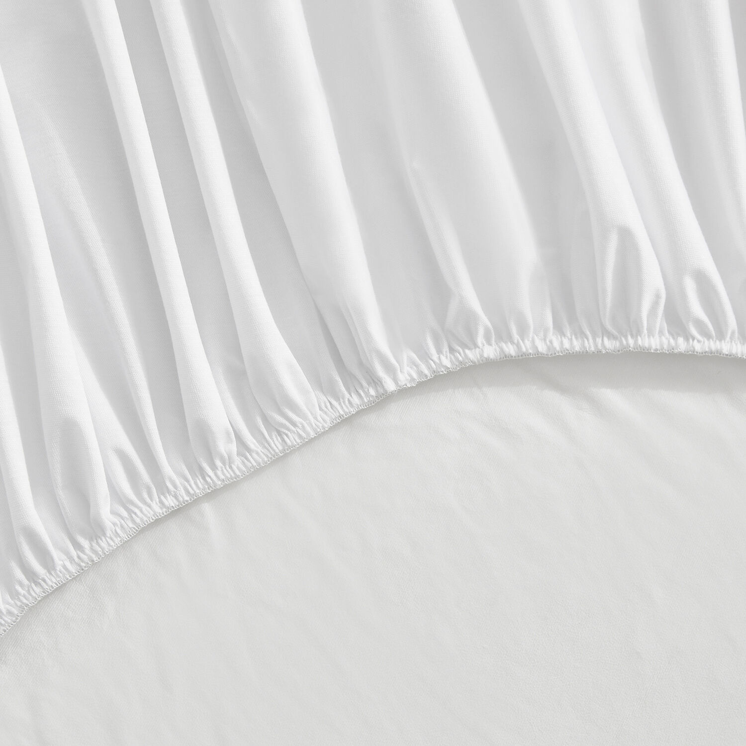 Primer plano de tela blanca con pliegues y borde elástico.