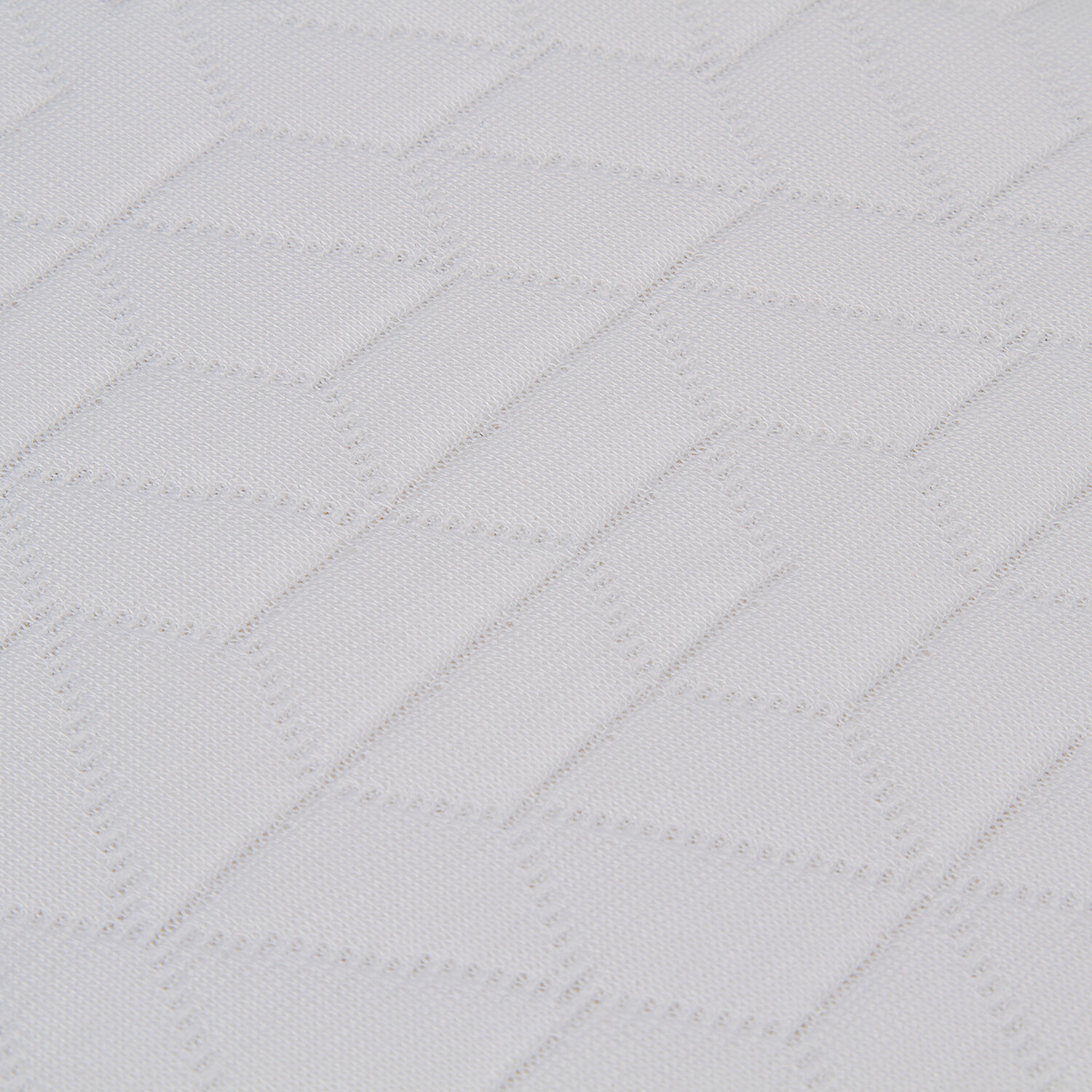 Primer plano de una textura acolchada blanca con patrón de diamantes.