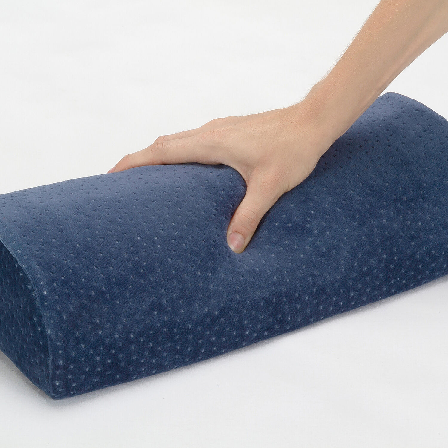 Una mano presiona un cojín azul texturizado.