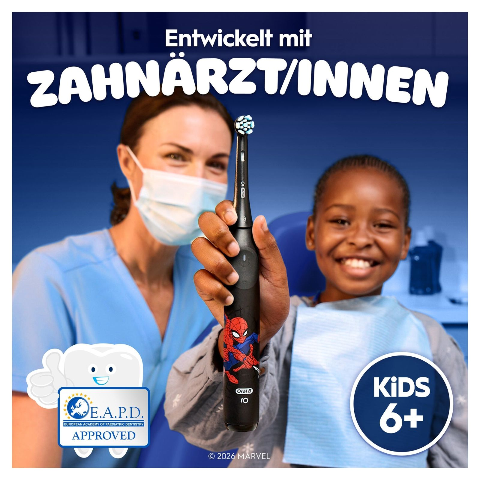 Dentystka w masce trzyma szczoteczkę Spidermana, chłopiec się uśmiecha.