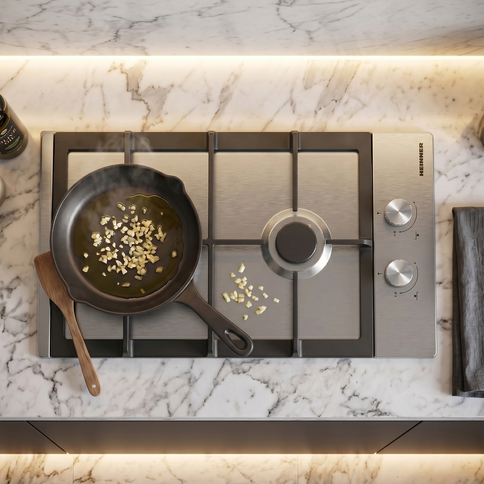 Cast iron skillet with garlic on gas stove with marble countertop and wooden spoon.