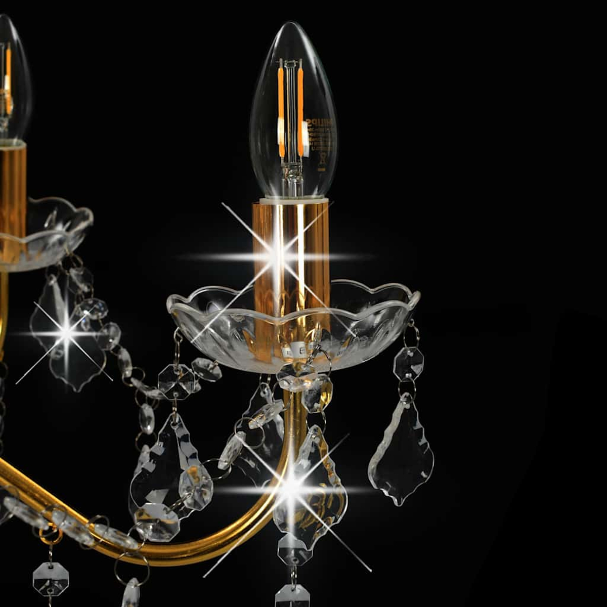 Eine goldene Lampe mit Kristallanhängern und Glühbirne.