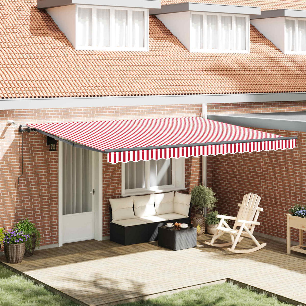 Eine rot-weiß gestreifte Markise bedeckt eine Terrasse mit Gartenmöbeln und Backsteinhaus.