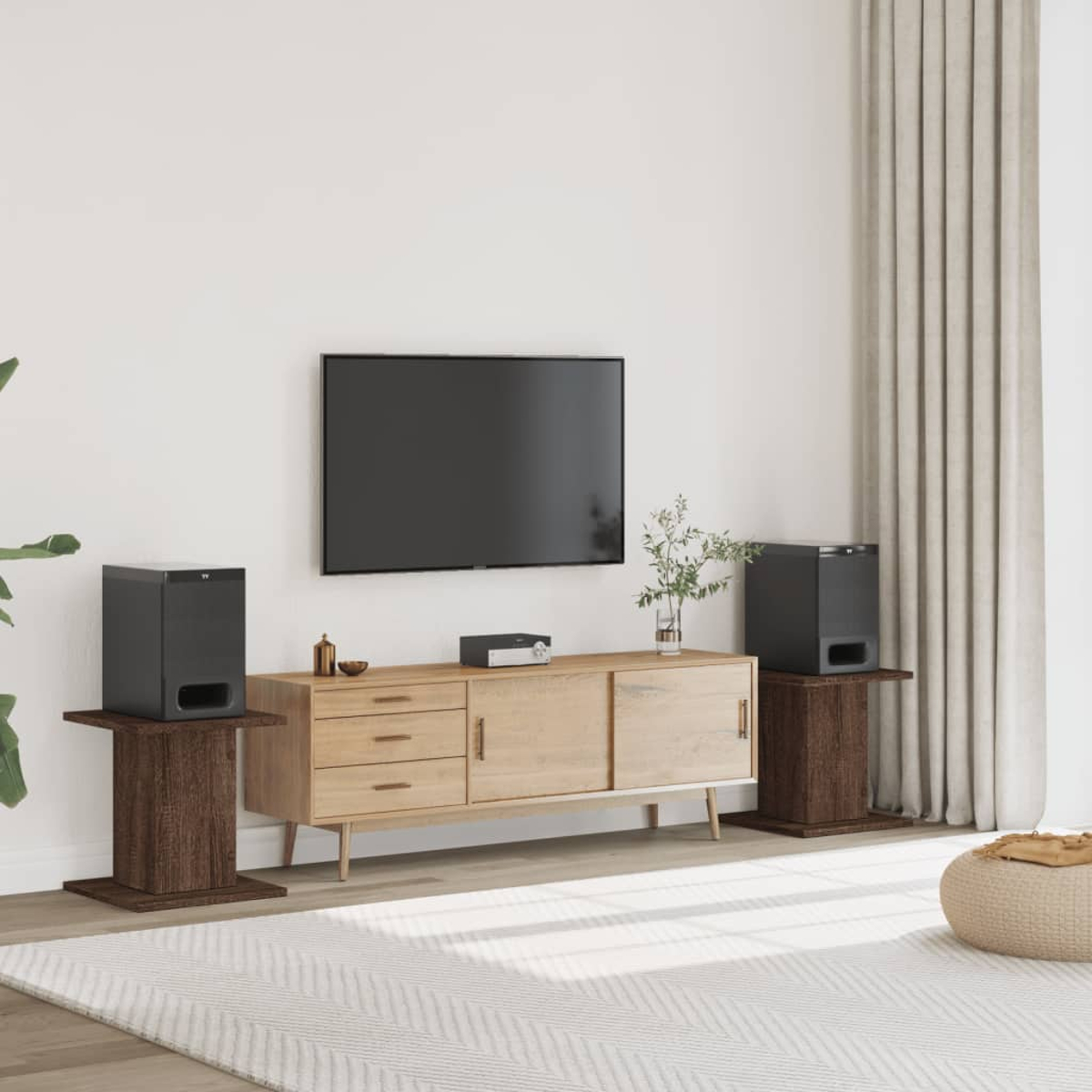 Ein Wohnzimmer mit einem Fernseher, einem Sideboard, zwei Lautsprechern auf Ständern und einem Teppich.