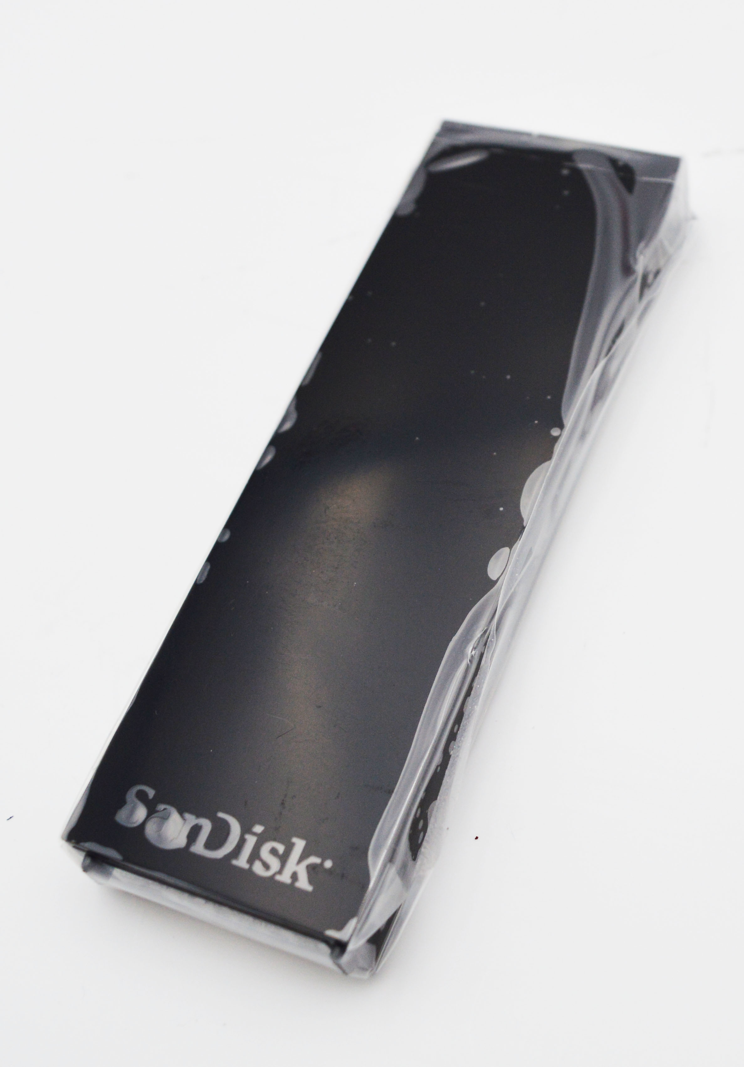 Ein schwarzes SanDisk-Speichermedium, verpackt in Plastik, auf weißem Hintergrund.