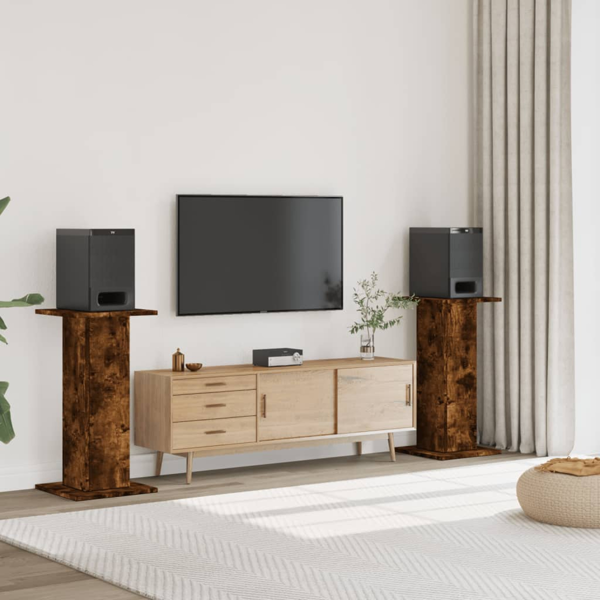 Ein Wohnzimmer-Setup mit Fernseher, Mediakonsole und zwei Lautsprechern auf Holzständern.