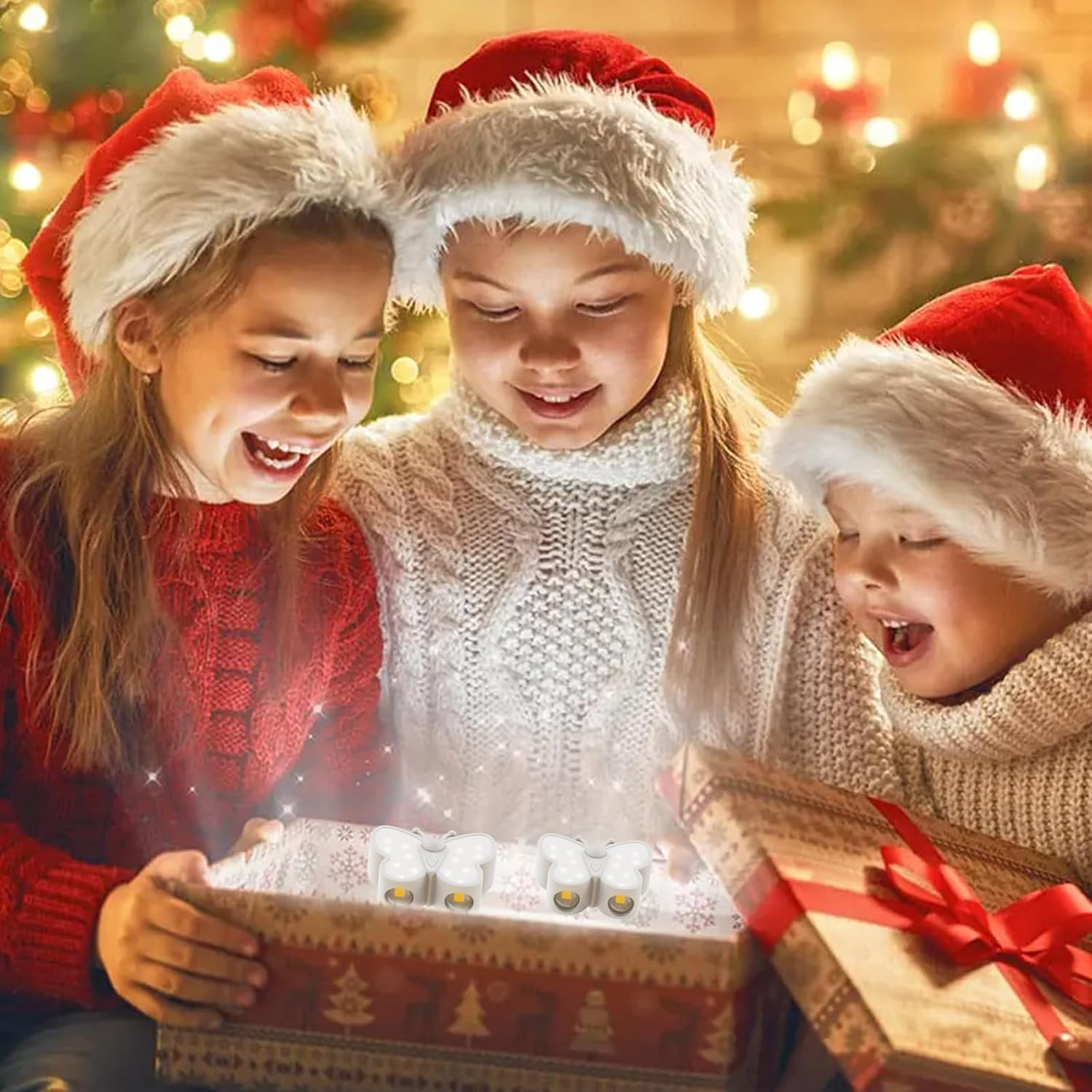 Drei Kinder in Weihnachtsmützen öffnen eine Geschenkbox mit leuchtenden Schmetterlingslichtern.