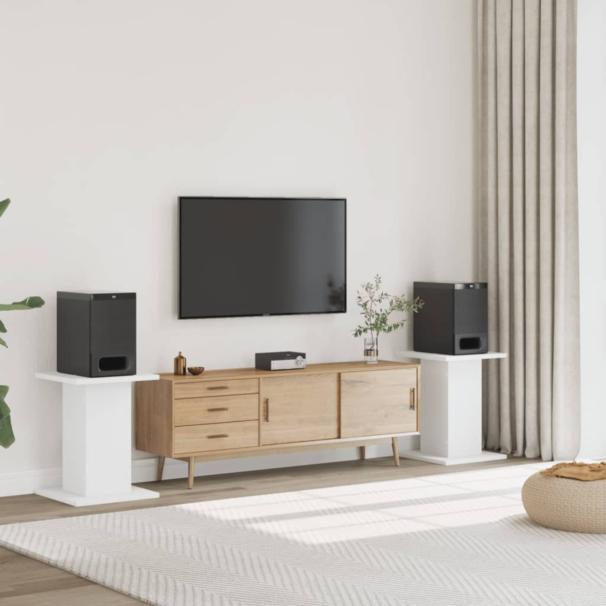 Ein Wohnzimmer mit Fernseher, Sideboard, zwei Subwoofern und Vorhängen.