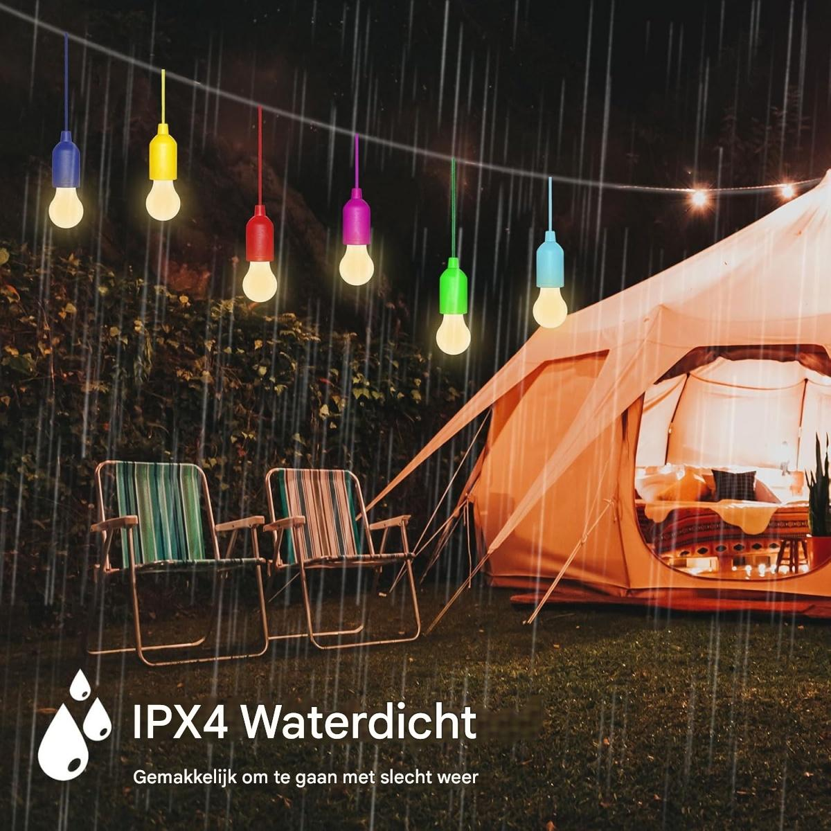 Bunte Lichterketten hängen über Stühlen und einem Zelt im Regen.